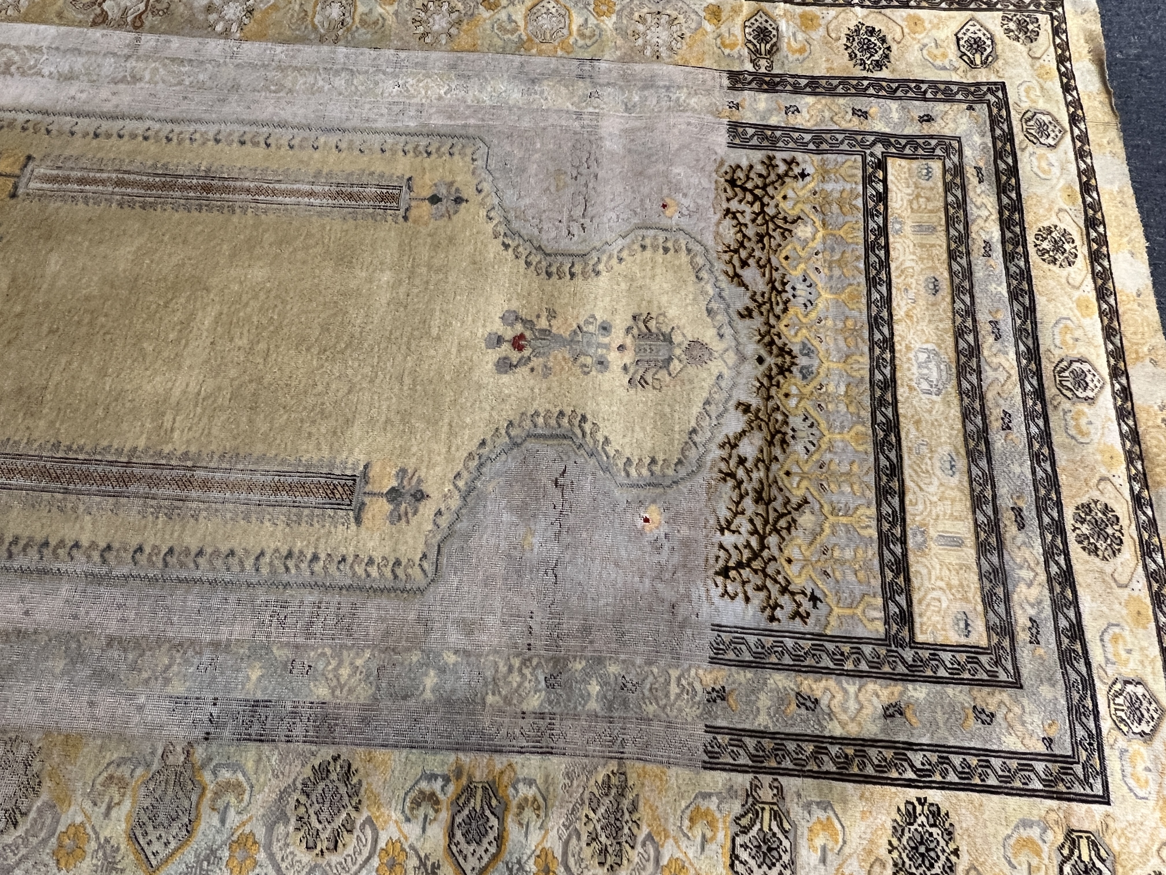 A Turkish silk prayer rug, with mihrab and stylised foliate borders on a gold ground, 185 x 137cm. Condition - the central panel severely worn to the tip of the mirror, lower fringe worn with losses.